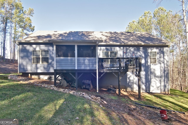 rear view of property with a sunroom, a yard, and a deck