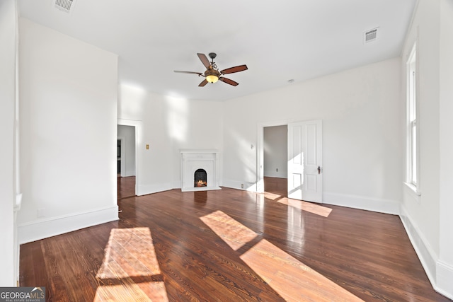 unfurnished living room with ceiling fan and dark wood-type flooring