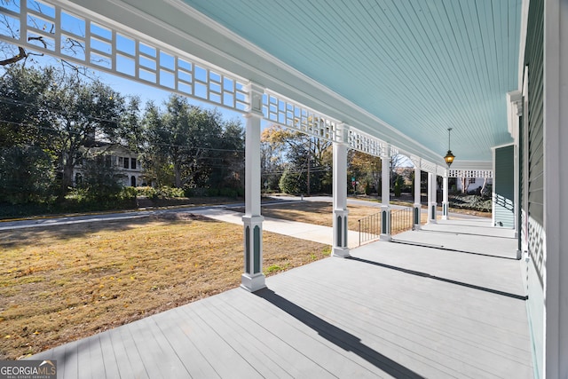 wooden deck with a lawn and a porch