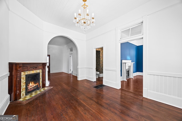 unfurnished living room with hardwood / wood-style floors, a fireplace, and a chandelier