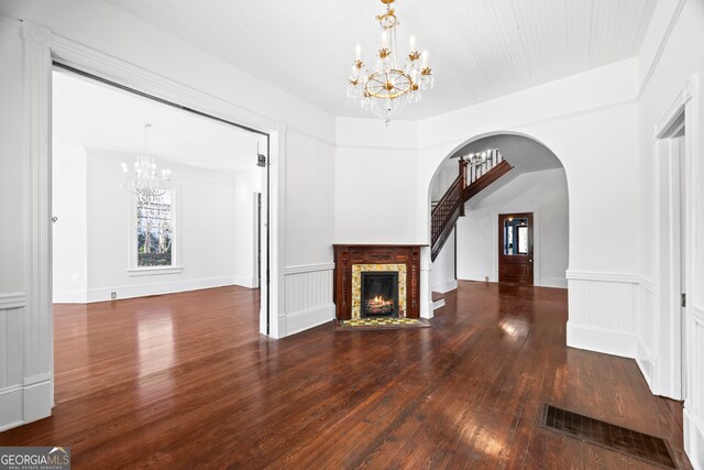 198 Dearing St, Athens, GA 30605 - unfurnished living room featuring hardwood / wood-style floors, arched walkways, a notable chandelier, a brick fireplace, and visible vents