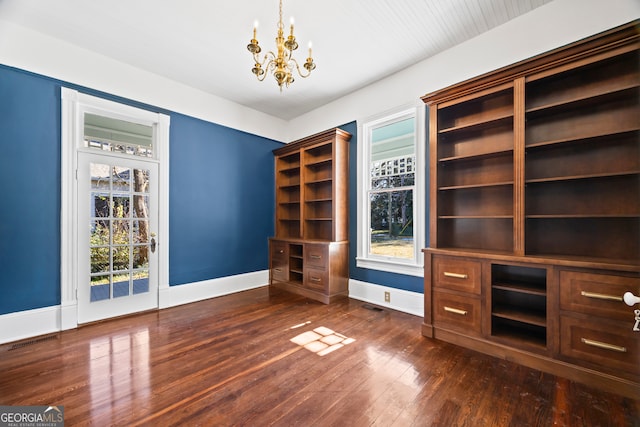 unfurnished office with dark hardwood / wood-style flooring and a chandelier