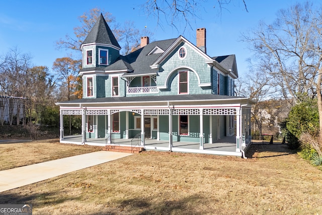 victorian house featuring covered porch and a front lawn