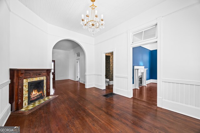 198 Dearing St, Athens, GA 30605 - unfurnished living room with arched walkways, visible vents, an inviting chandelier, wood finished floors, and a warm lit fireplace