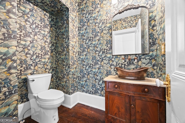 bathroom with hardwood / wood-style flooring, vanity, and toilet