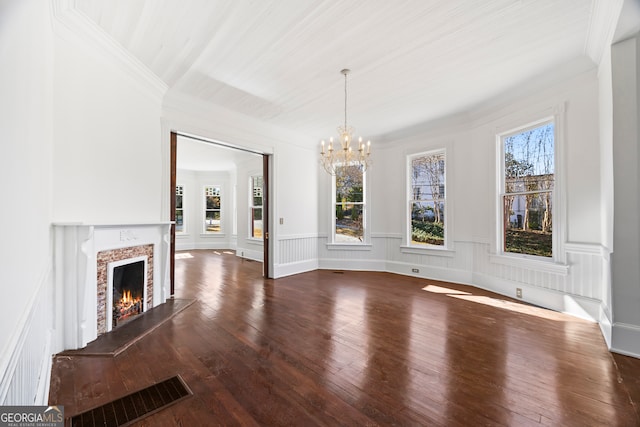 unfurnished dining area with hardwood / wood-style flooring, a premium fireplace, and a chandelier