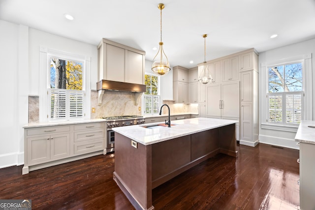 kitchen with light stone countertops, dark hardwood / wood-style flooring, range with two ovens, and sink