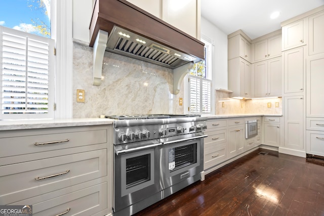 kitchen featuring range with two ovens, built in microwave, tasteful backsplash, plenty of natural light, and custom range hood