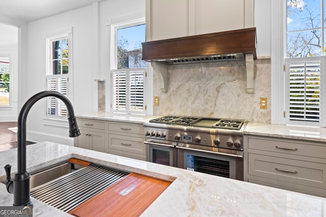 198 Dearing St, Athens, GA 30605 - kitchen featuring plenty of natural light, decorative backsplash, double oven range, custom range hood, and light stone countertops
