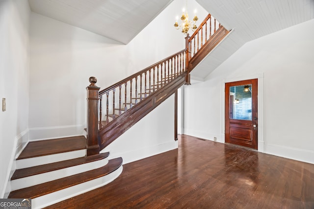 entrance foyer with hardwood / wood-style flooring, lofted ceiling, and an inviting chandelier