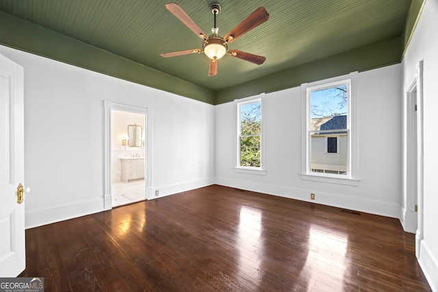 empty room with ceiling fan and dark wood-type flooring