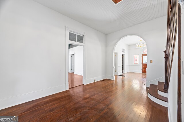 198 Dearing St, Athens, GA 30605 - spare room with arched walkways, baseboards, hardwood / wood-style flooring, stairs, and a notable chandelier