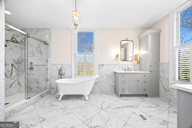 bathroom with vanity, tile walls, and shower with separate bathtub