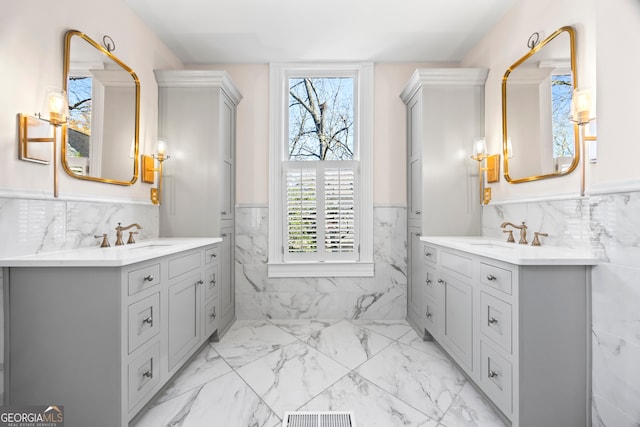 bathroom with vanity, plenty of natural light, and tile walls