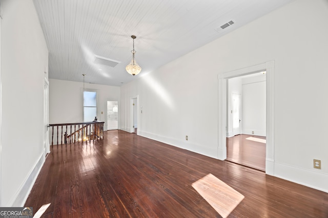 unfurnished room featuring a chandelier and hardwood / wood-style flooring