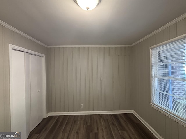 unfurnished bedroom with dark wood-type flooring, a closet, and crown molding