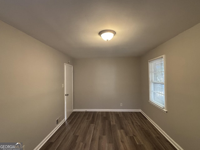 spare room featuring dark wood-type flooring