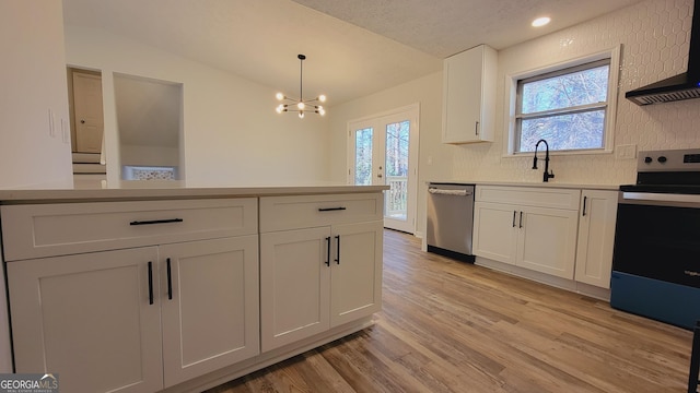 kitchen with premium range hood, lofted ceiling, decorative light fixtures, white cabinets, and appliances with stainless steel finishes