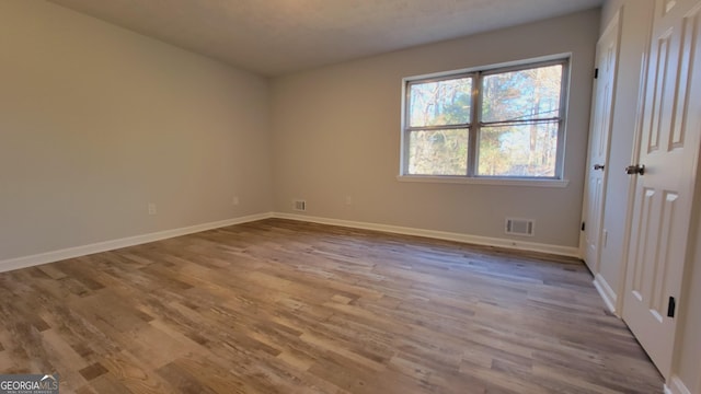 empty room with light hardwood / wood-style flooring