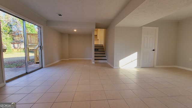 spare room with light tile patterned floors and a textured ceiling