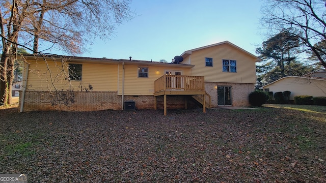 rear view of house featuring a wooden deck and central AC