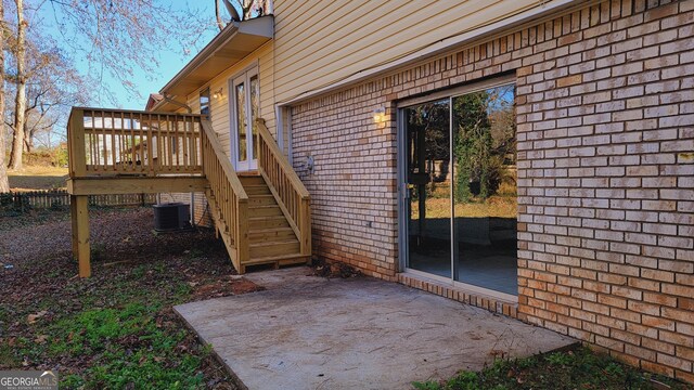 doorway to property featuring a deck, cooling unit, and a patio area