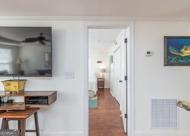 hallway featuring crown molding and dark wood-type flooring