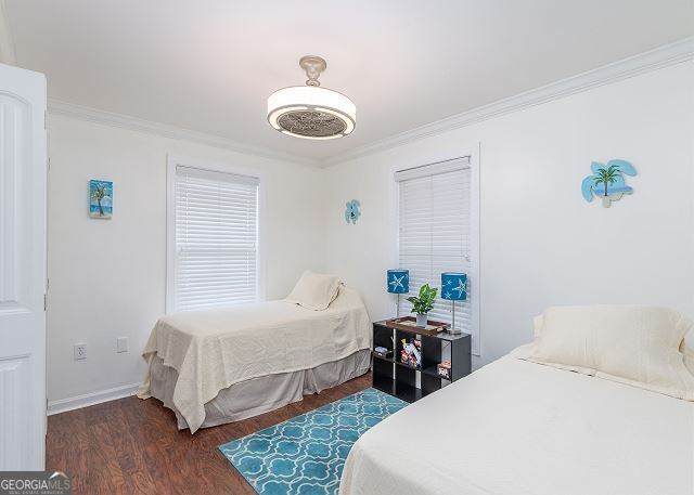 bedroom featuring dark hardwood / wood-style floors and ornamental molding