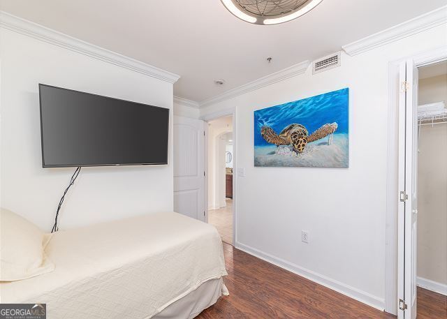 bedroom featuring wood-type flooring and ornamental molding