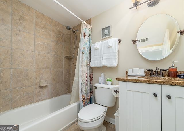 full bathroom with vanity, toilet, and shower / tub combo with curtain