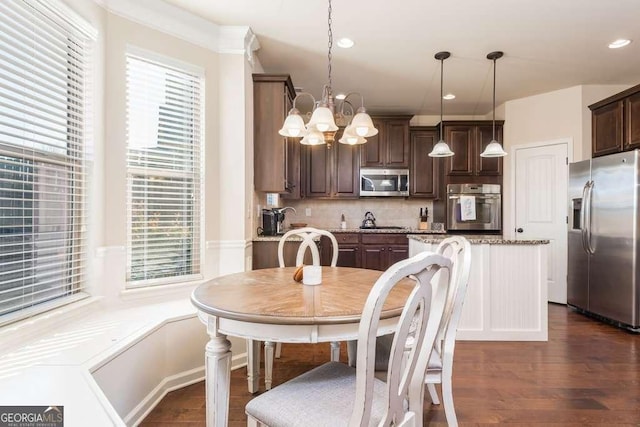 dining room featuring crown molding, dark hardwood / wood-style flooring, and a notable chandelier