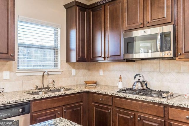 kitchen with plenty of natural light, sink, stainless steel appliances, and tasteful backsplash