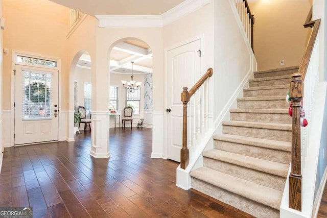 foyer with beamed ceiling, a healthy amount of sunlight, ornamental molding, and coffered ceiling