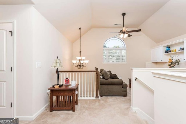 sitting room with ceiling fan with notable chandelier, lofted ceiling, and light carpet