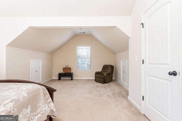 bedroom with light colored carpet and lofted ceiling