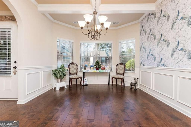 living area with beam ceiling, dark hardwood / wood-style flooring, an inviting chandelier, and ornamental molding