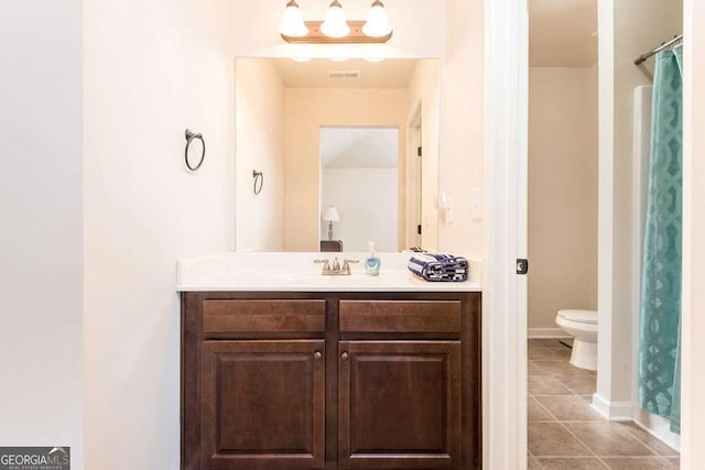 bathroom featuring tile patterned flooring, vanity, and toilet