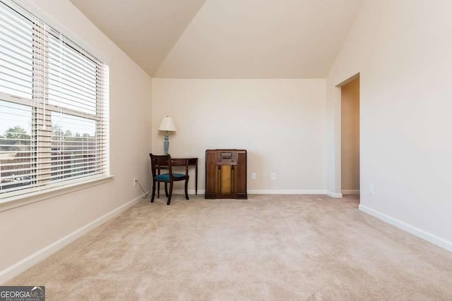 interior space featuring light carpet and vaulted ceiling