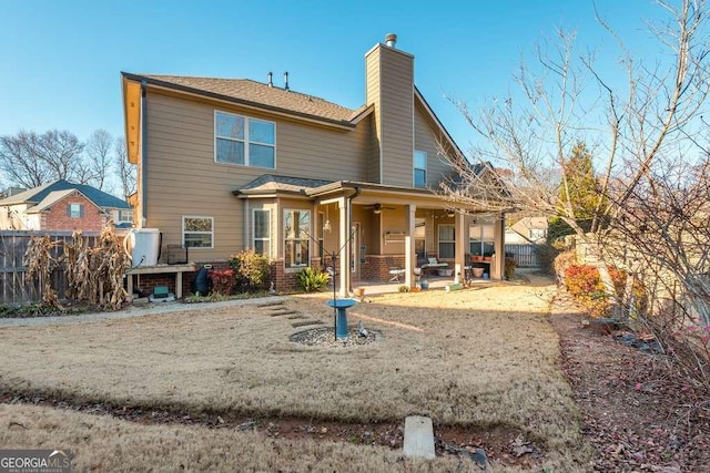 rear view of house featuring ceiling fan and a patio area