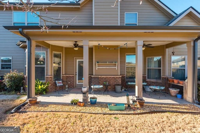 rear view of property featuring ceiling fan and a patio area