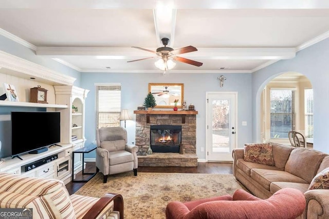 living room featuring coffered ceiling, a stone fireplace, ornamental molding, beamed ceiling, and wood-type flooring