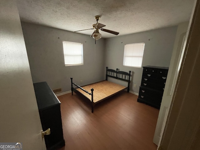 unfurnished bedroom with ceiling fan, hardwood / wood-style floors, and a textured ceiling