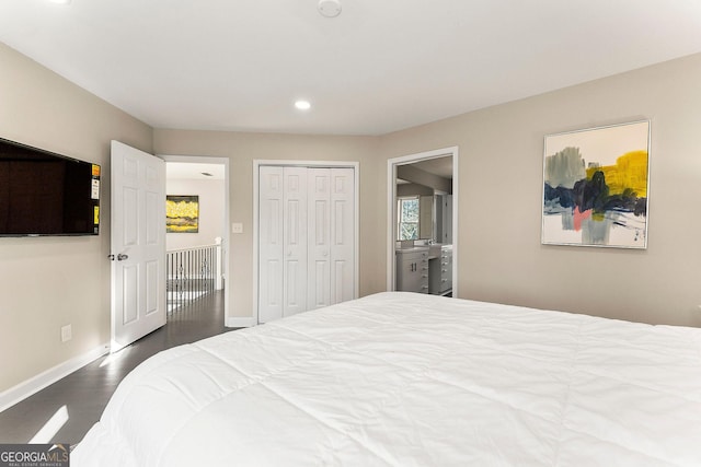 bedroom with ensuite bathroom, a closet, and dark hardwood / wood-style floors