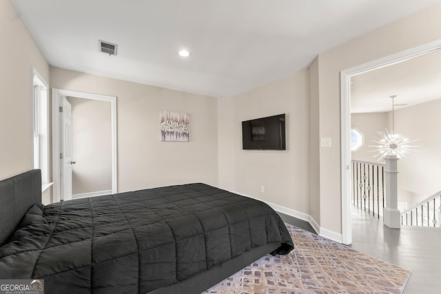 bedroom with wood-type flooring and a notable chandelier