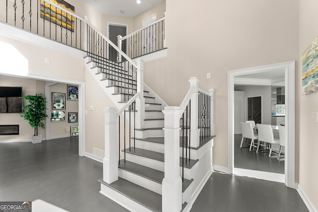 stairs featuring hardwood / wood-style floors and a high ceiling