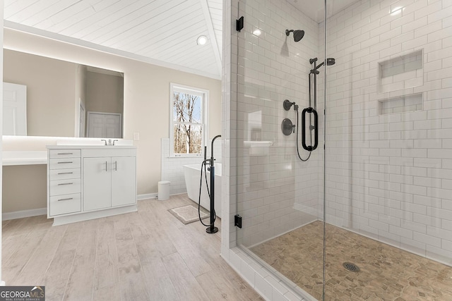 bathroom with wood-type flooring, vanity, and shower with separate bathtub