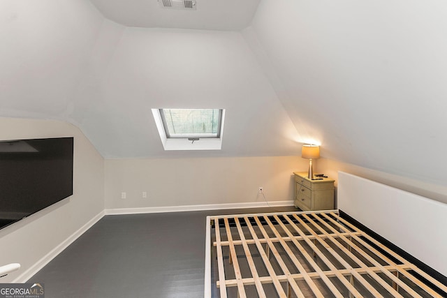 interior space with vaulted ceiling with skylight