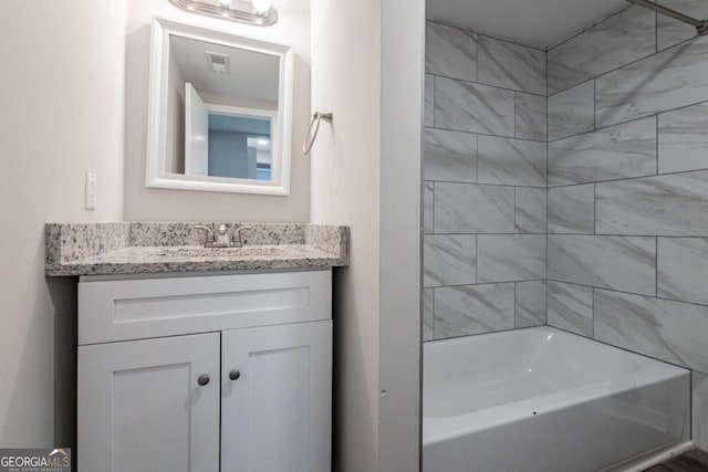 bathroom featuring vanity and tiled shower / bath