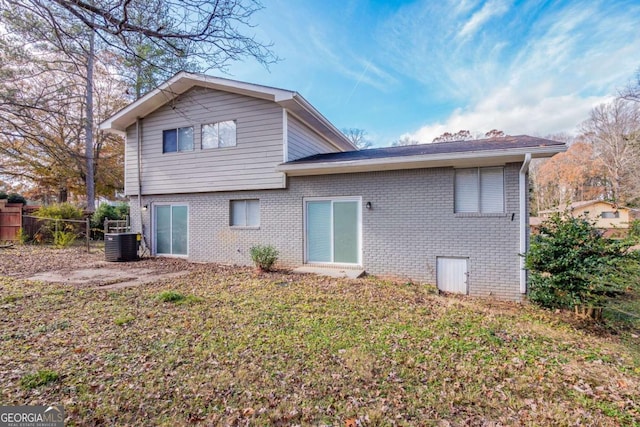 back of property with a lawn and central air condition unit