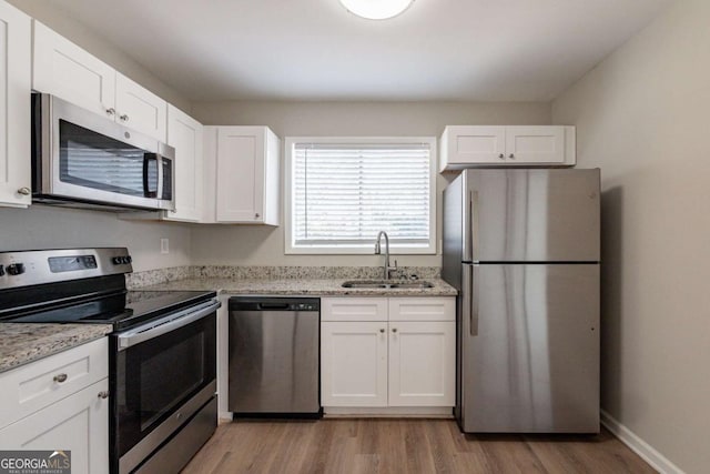 kitchen featuring light stone countertops, sink, white cabinets, and appliances with stainless steel finishes